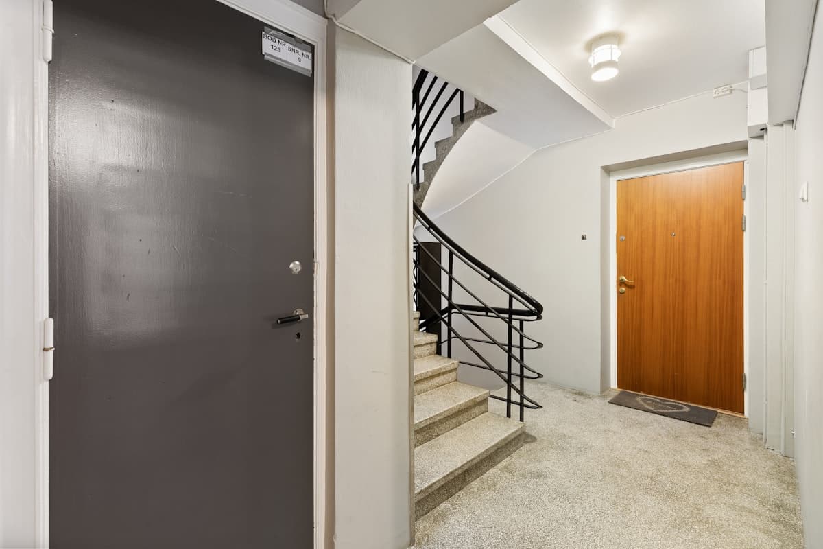 Clean residential hallway with stairwell and modern finishes